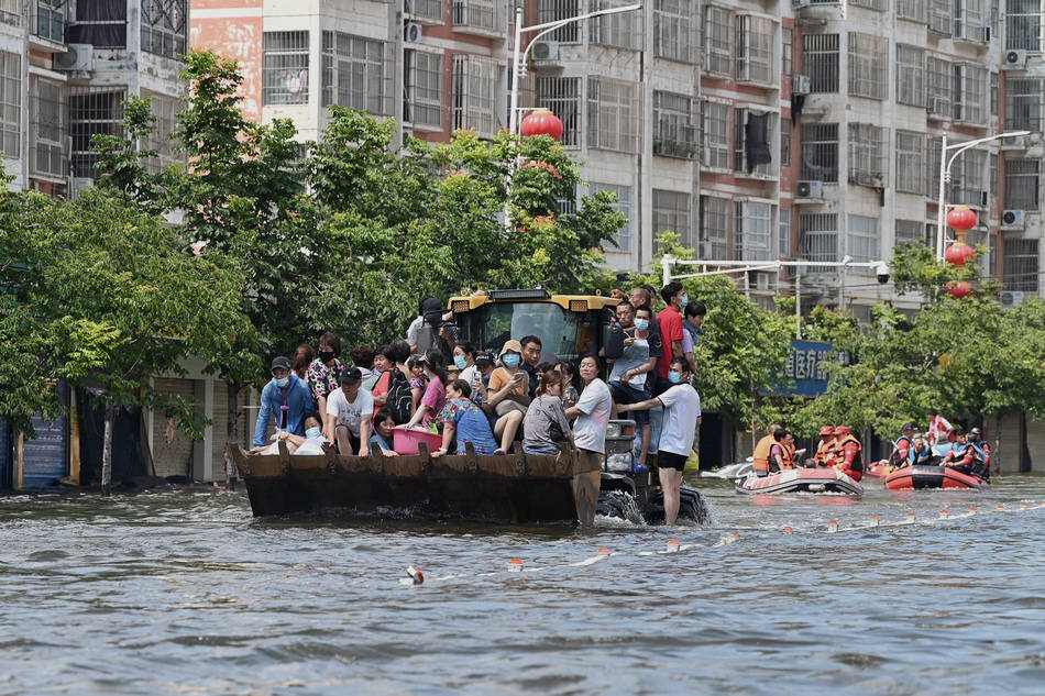 2021年7月26日,卫辉市振兴路,一辆平板卡车满载着被困群众行驶在积水