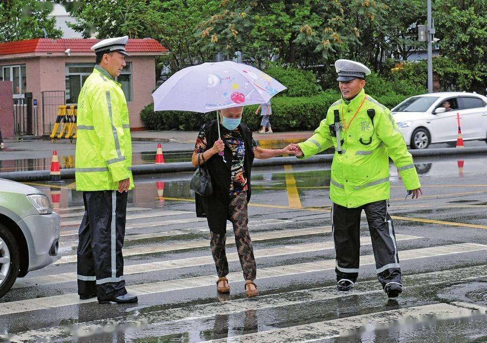 7月29日清晨,天桥交警大队民警在雨中搀扶老人过马路.