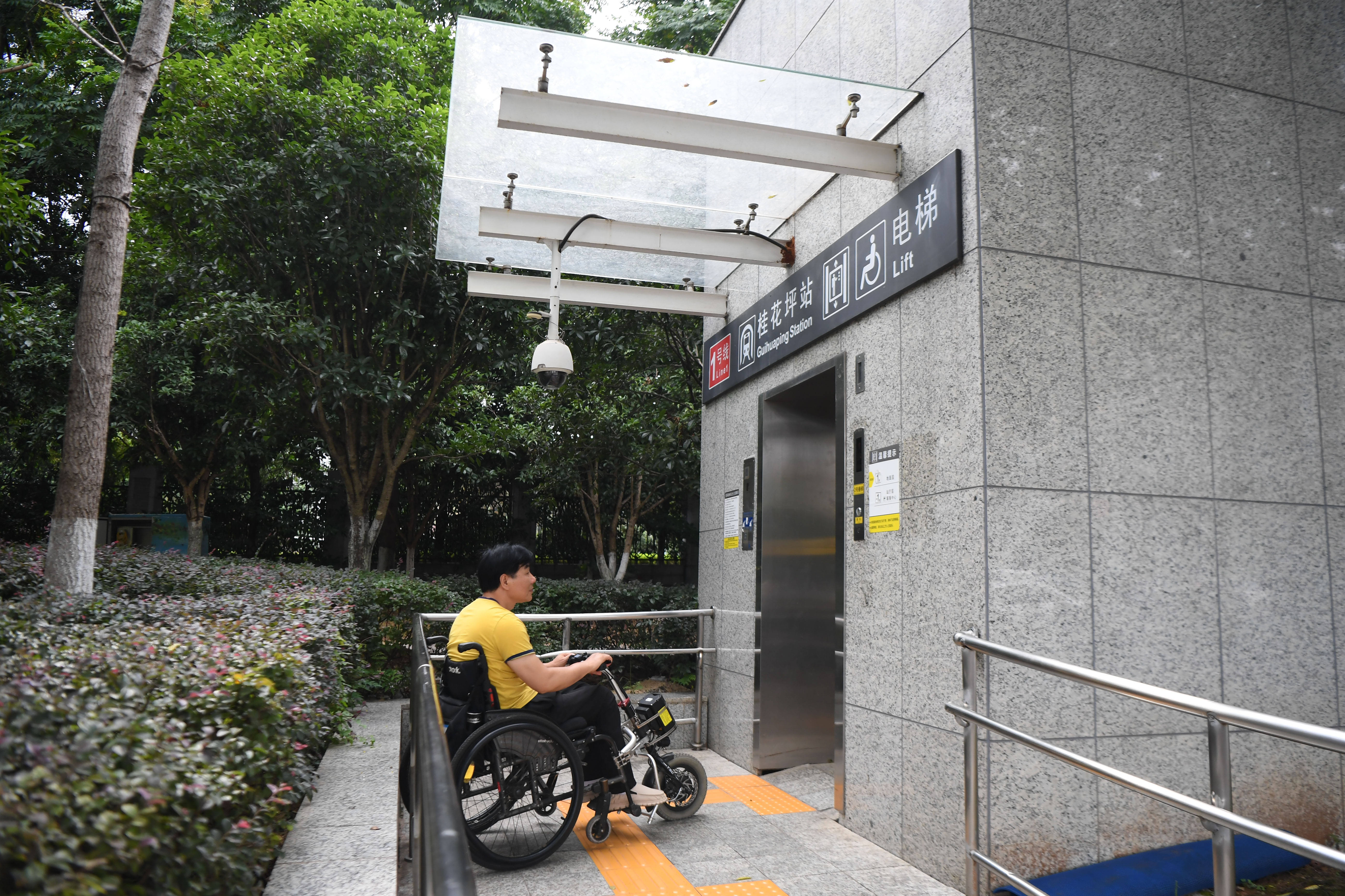 残疾人生活更便利8月25日,伍树林在湖南省长沙市桂花坪地铁站外等候无
