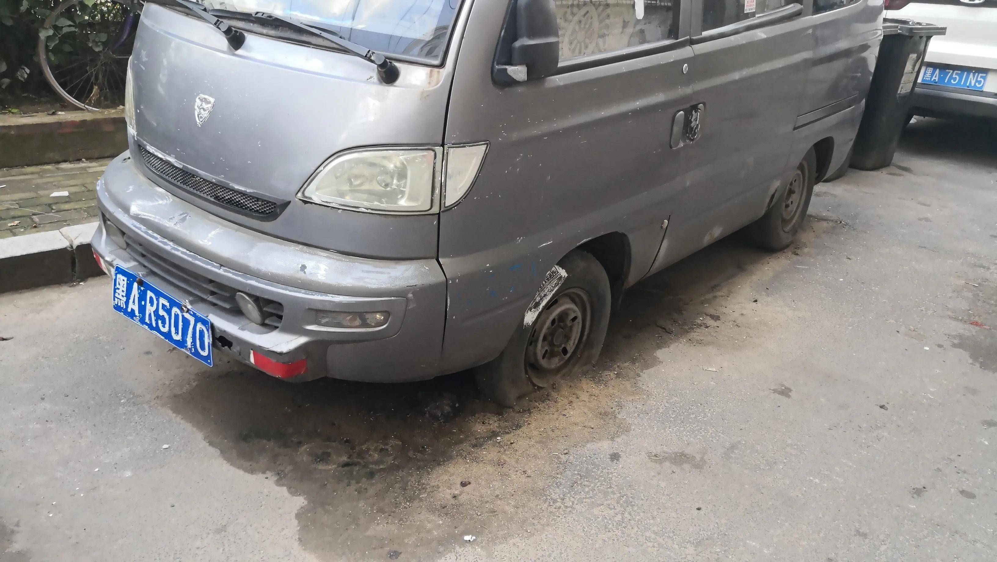 8日,哈尔滨市南岗区龙江街上,一辆废弃的哈飞面包车与其他僵尸车一起