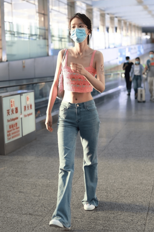 粉色吊带背心搭配蓝色牛仔裤乔欣机场走秀美出新境界