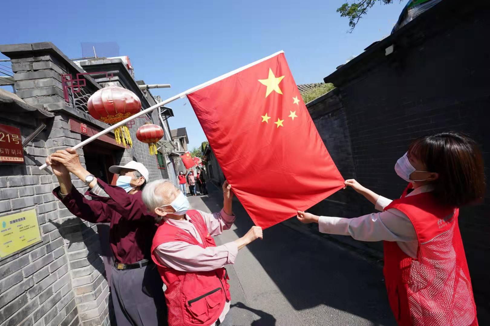 在什刹海街道大石作胡同,居民将鲜艳的五星红旗挂起,喜迎国庆.