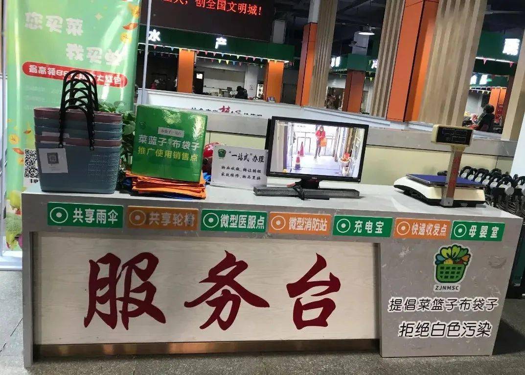 菜市场内合适位置高高悬挂起各式宣传标语,市场服务台及每个摊