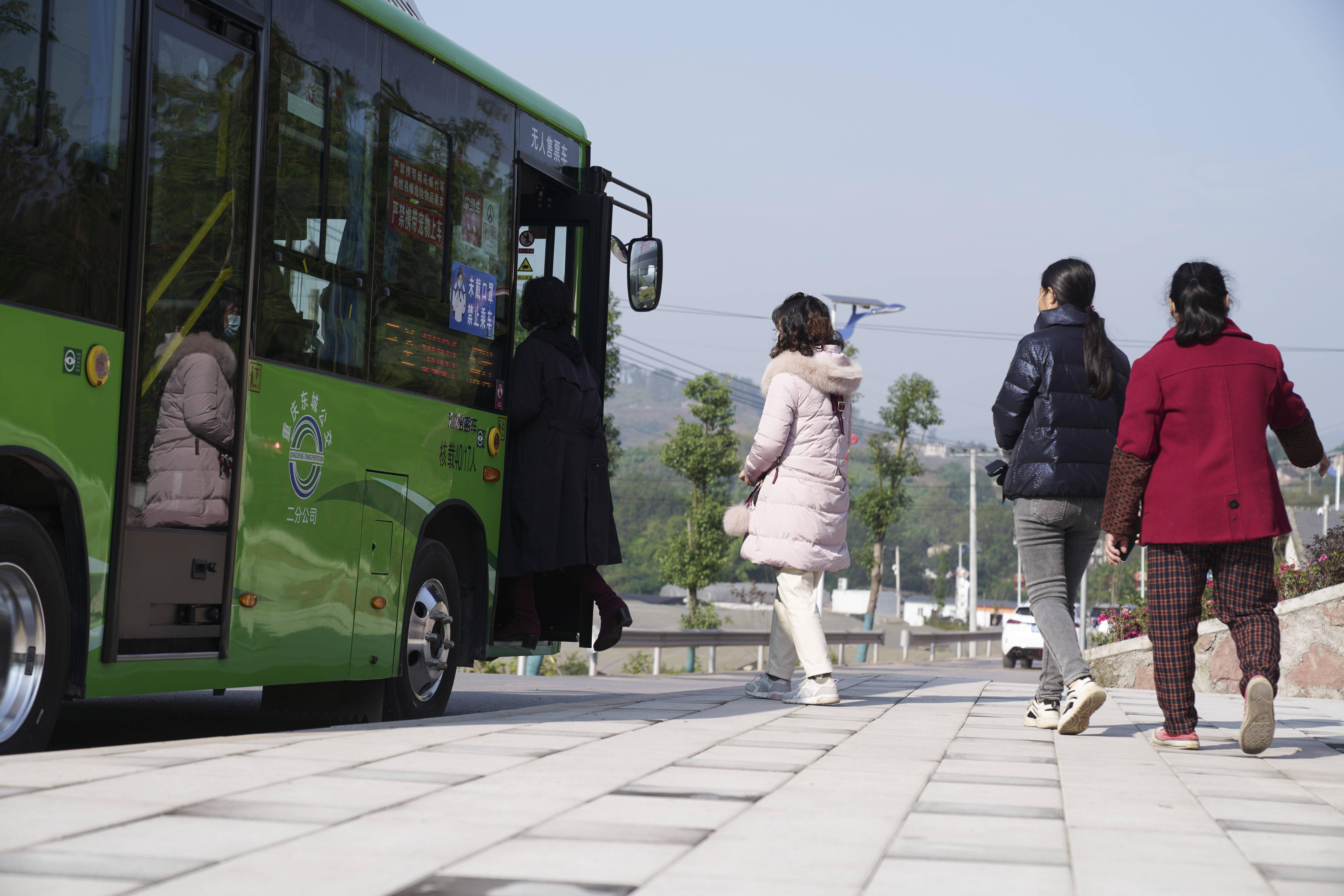 11月26日,在重庆市北碚区三圣镇春柳村公交车站,当地村民排队乘坐公交