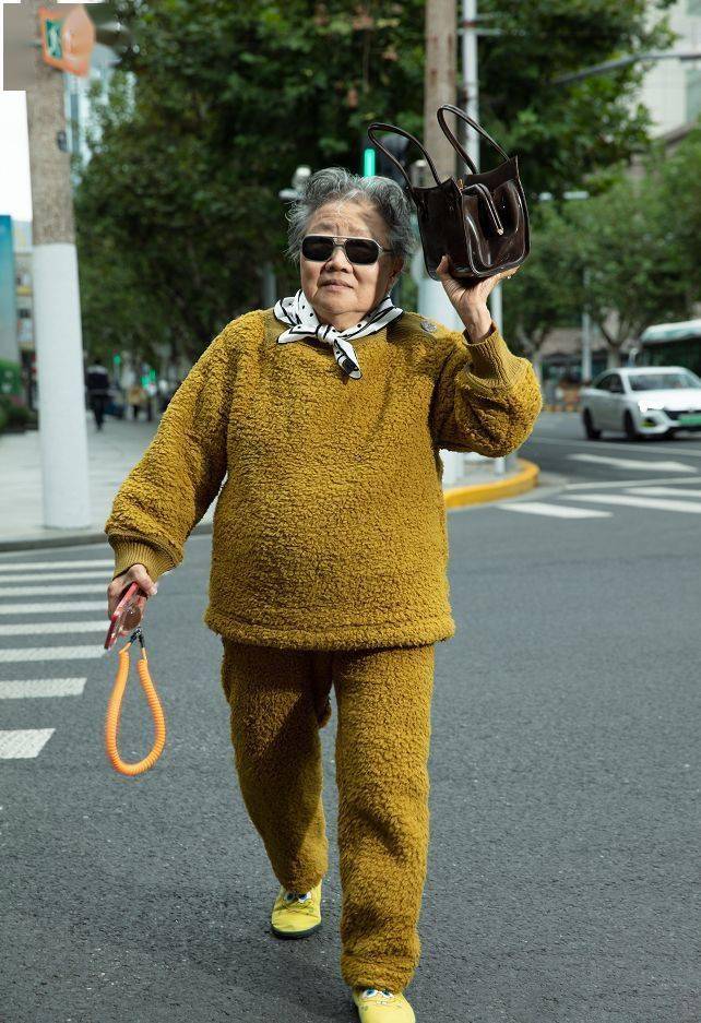 这位上海大妈采用了时下流行的光腿神器穿搭,风衣配肉色丝袜,轻松