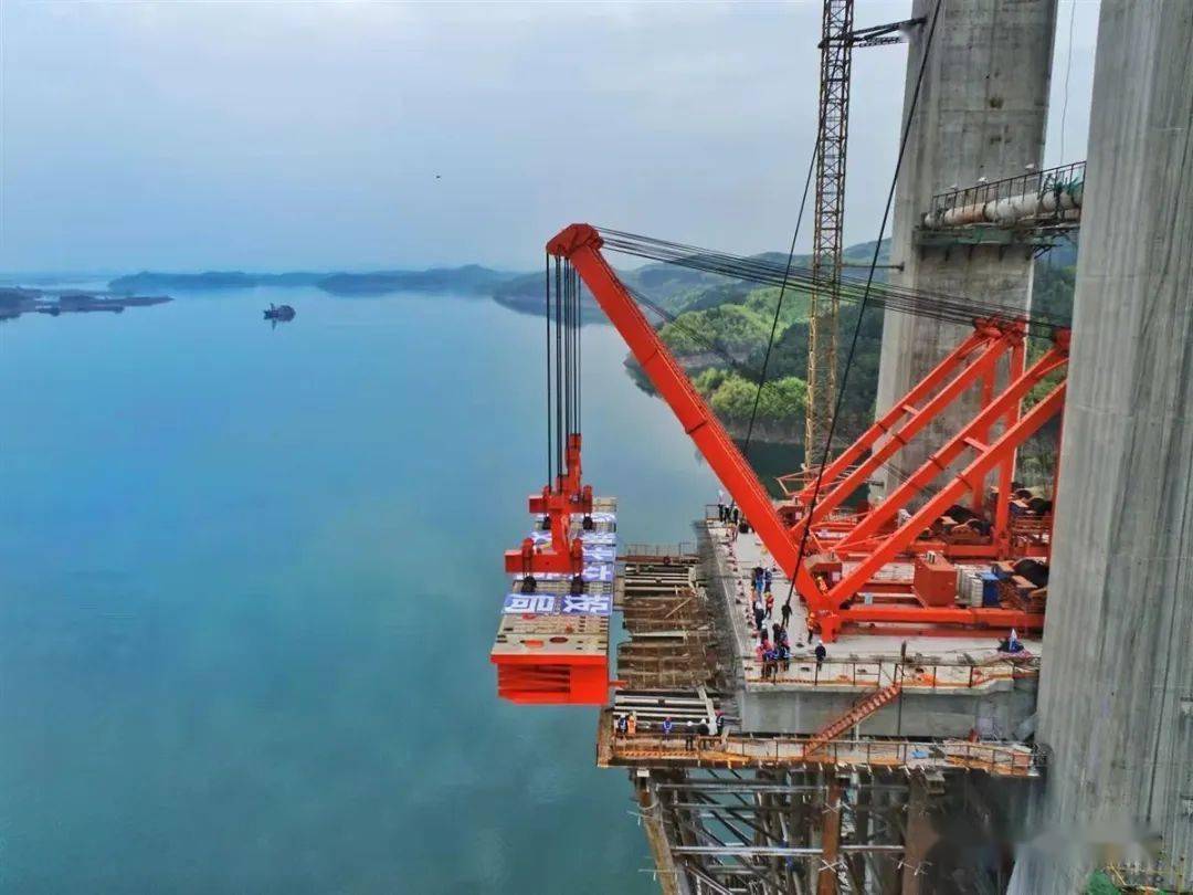 场运至大桥施工现场,经过吊绳固定后,2台290吨变幅式桥面吊机缓缓起吊