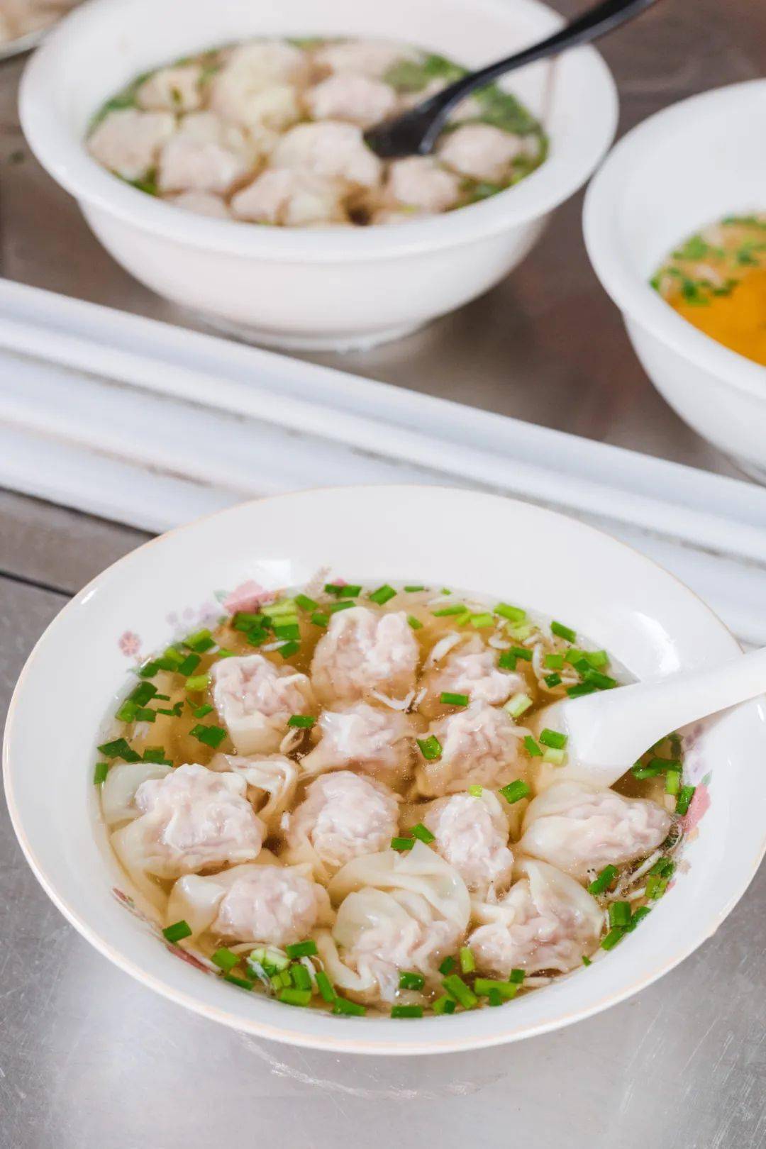 煮熟的馄饨像一只只水母浮游于瓷碗之中,清亮的汤底飘着青葱与虾米,惹