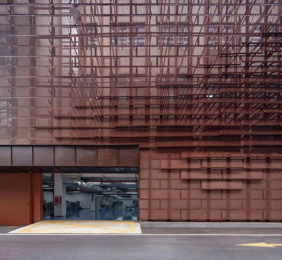 其余立面也被蒙上了砖红色的金属网,与当今流行的工业风街区有着异曲