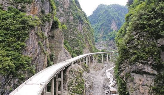 在綿茂公路的一處隧道口上,代表香港特區的紫荊花標誌熠熠生輝.