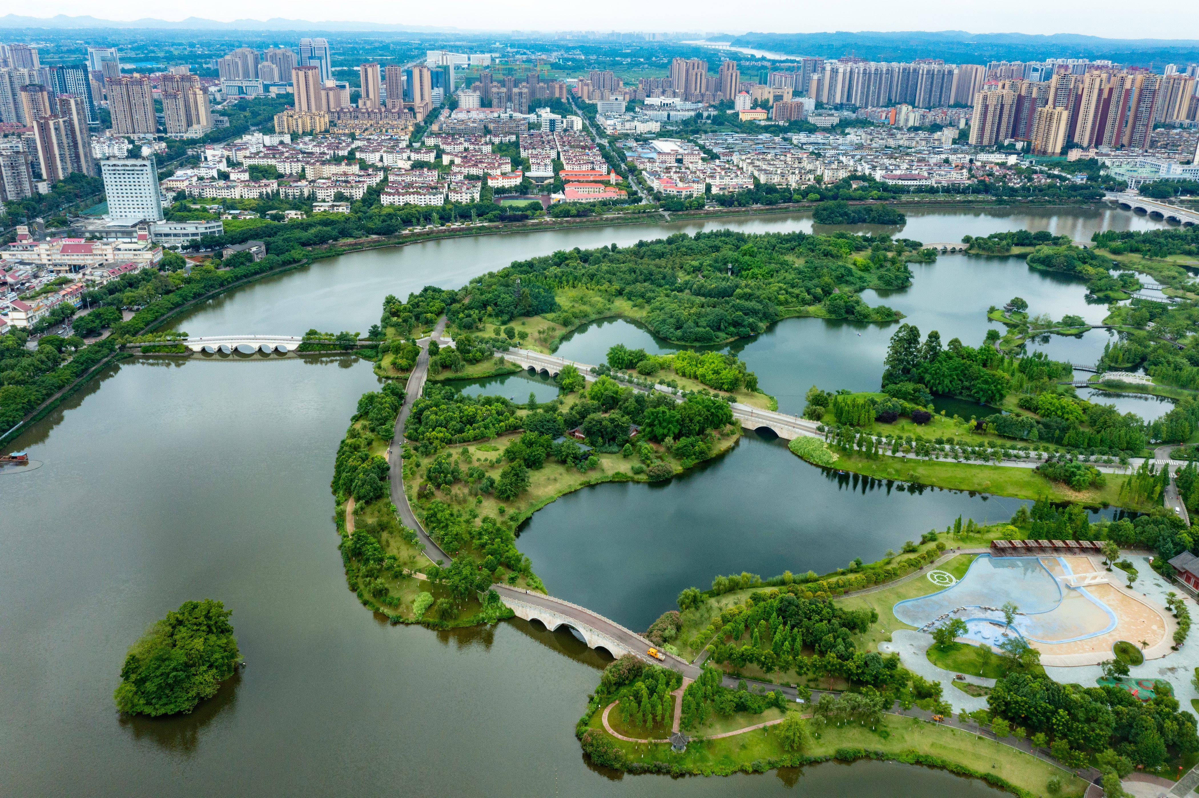 这是无人机拍摄的眉山东坡城市湿地公园全景(中)和周边建筑群(6月23日