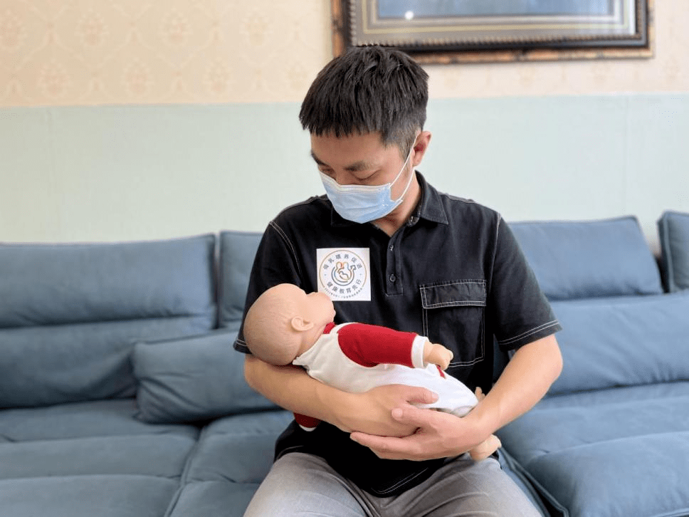 橄榄球式抱法爸爸先将宝宝的身体夹在一侧腋下,而宝宝的上半身及头部