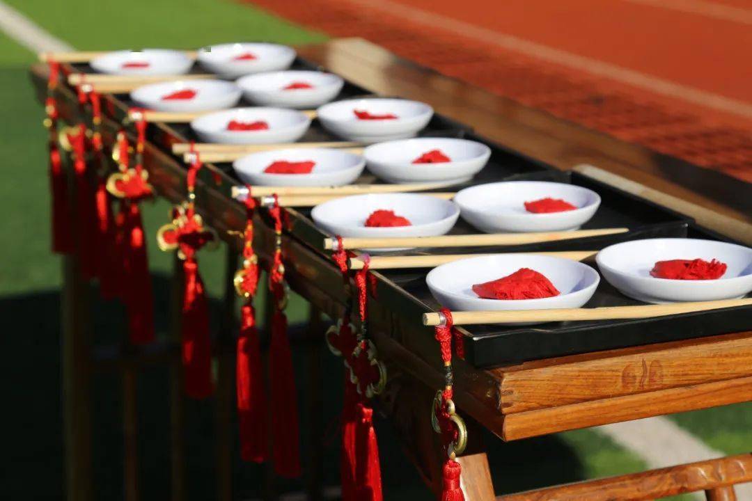 们正衣冠,孩子们向老师行拜师礼,校领导和老师为每个孩子"朱砂启智"