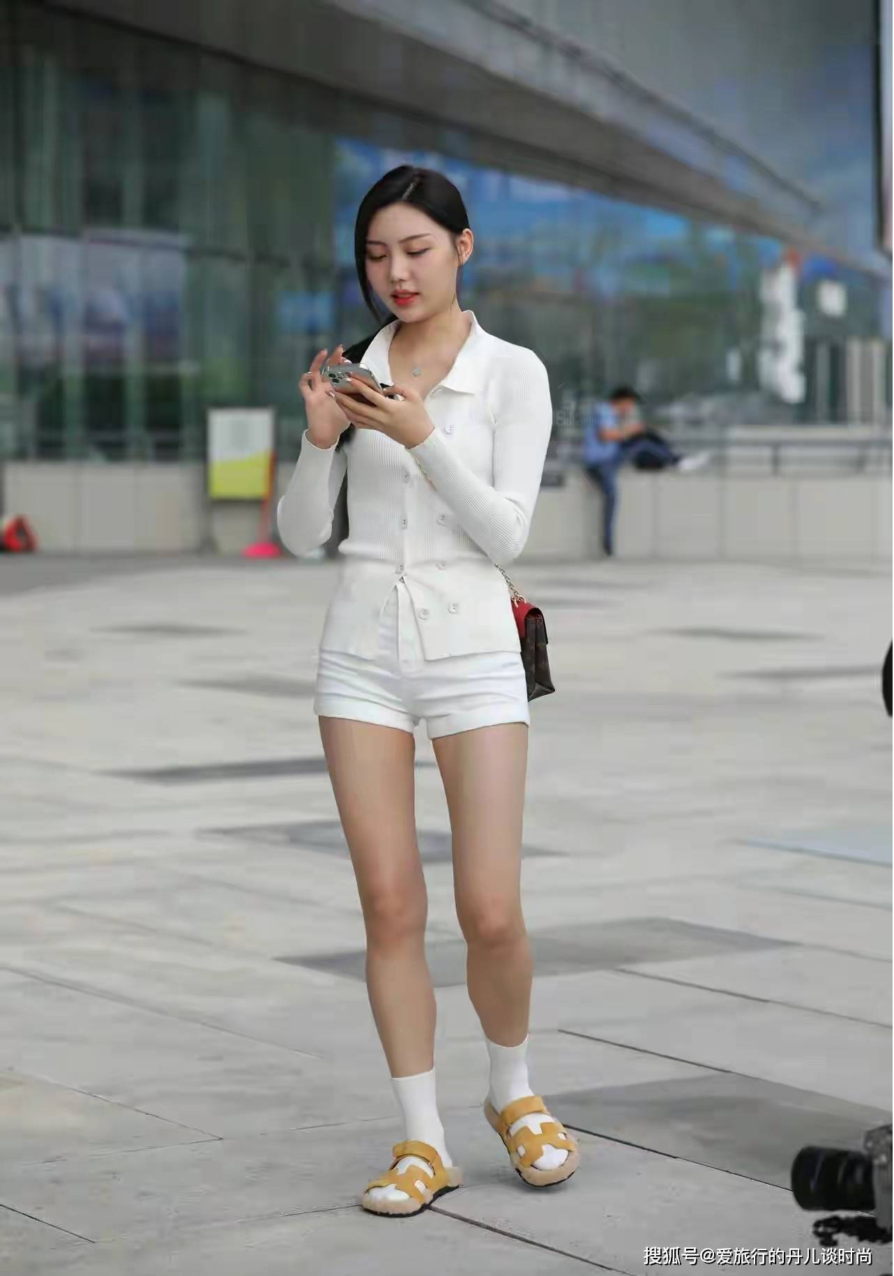 美女身穿白色翻领针织衫搭配白色休闲短裤,清新淡雅,脚踩白色短袜和姜