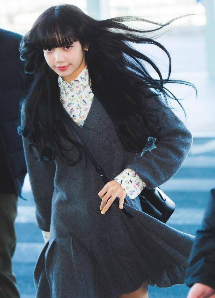 lisa现身机场,黑色长卷发搭配灰色针织连身裙,仿佛动漫里走出的女孩