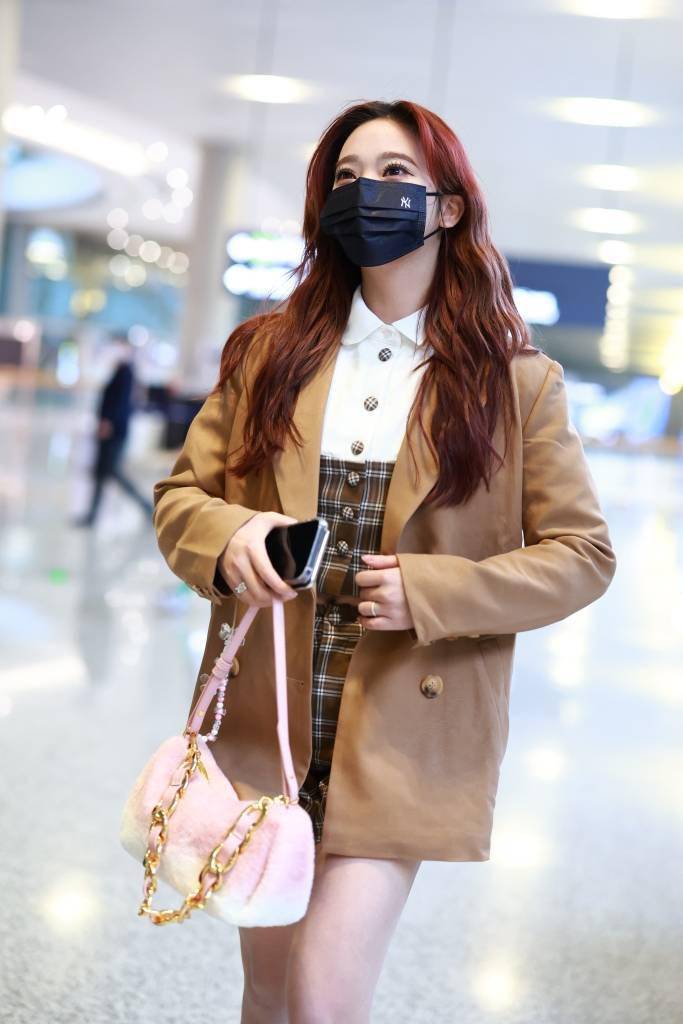 张紫宁身穿卡其色西装搭配格纹短裙和马丁靴,学院风造型现身虹桥机场