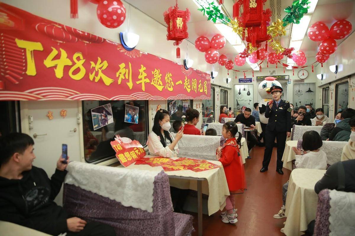 火红的窗花,精致的花灯早早被工作人员布置在了t48次列车的餐车里
