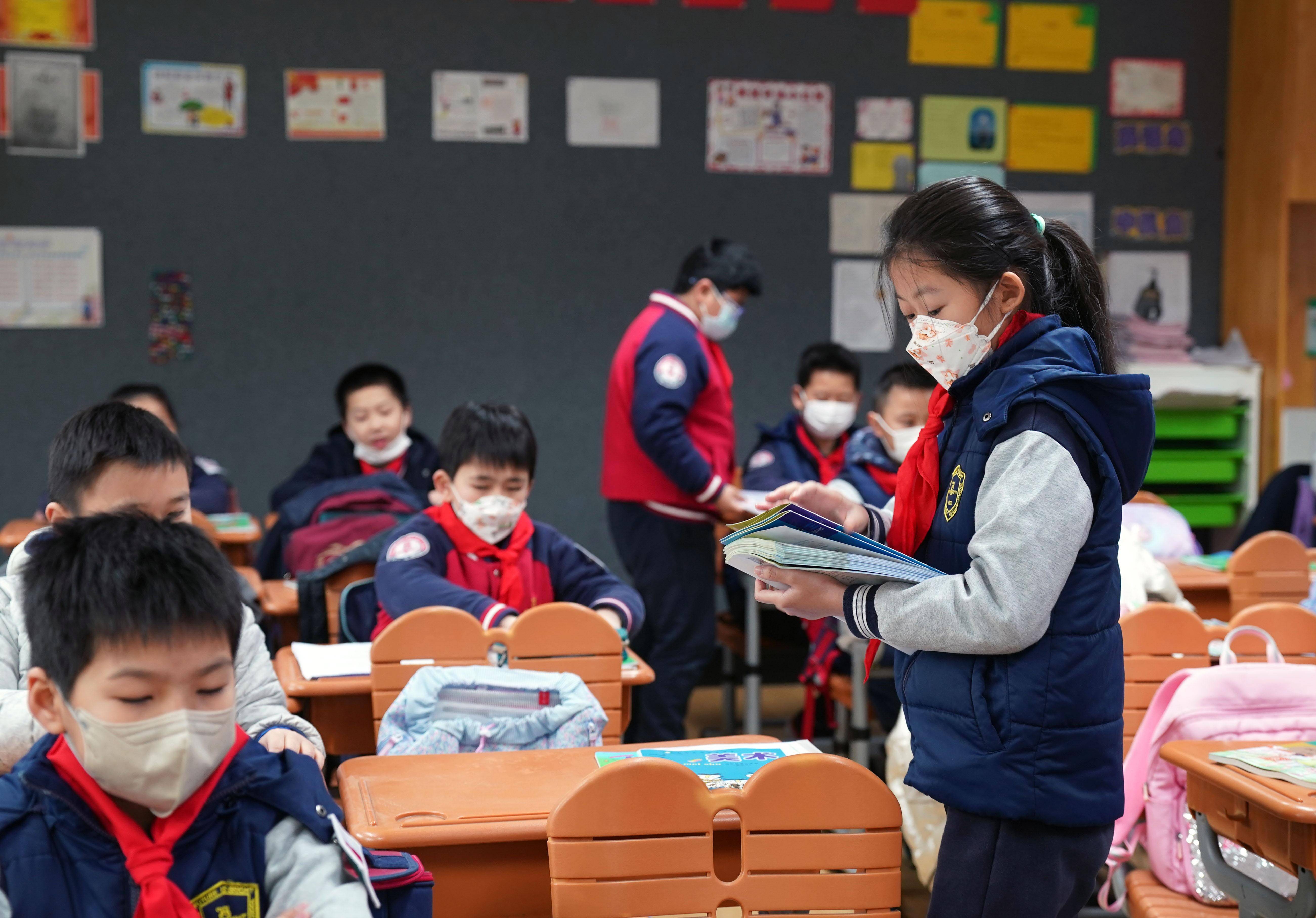 2月13日,在上海市长宁区天山第一小学,返校学生在走廊阅读新学期体育