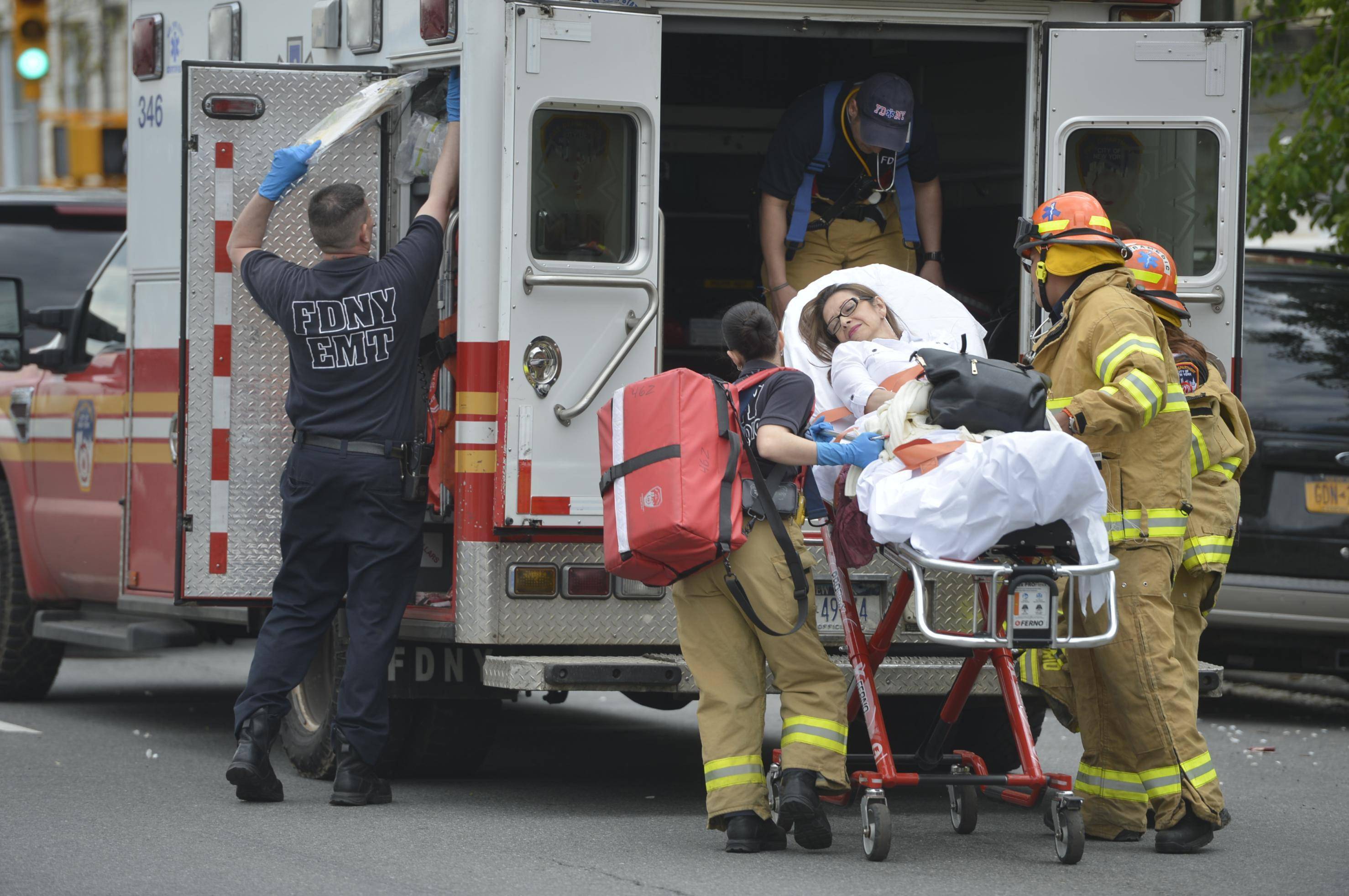 纽约皇后区发生地铁列车脱轨的地段,一名受伤乘客被救援人员送上救护