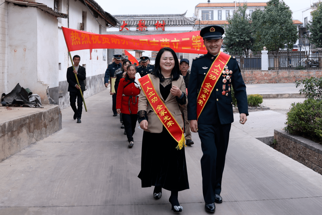 有同志先进事迹,并为其家属佩戴绶带和大红花,送上"二等功臣之家"牌匾