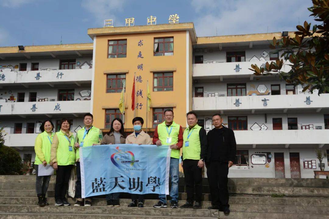 在三甲街道三甲中学,蓝天助学协会一行走进教室查看了课桌的使用状况