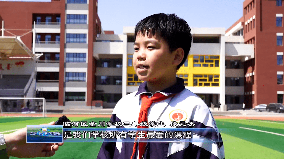 在临河区金川学校的操场上,传统体育游戏"弹弹珠"正在进行,经过老师的