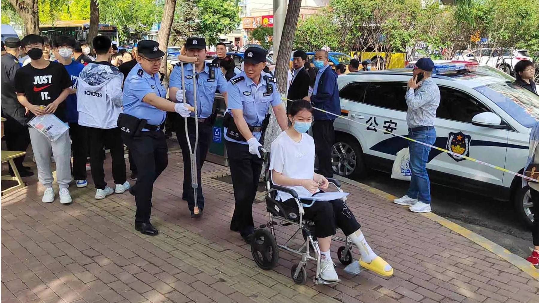 道里分局工农派出所民警护送腿部受伤考生进考场(央广网发 郑威 摄)8