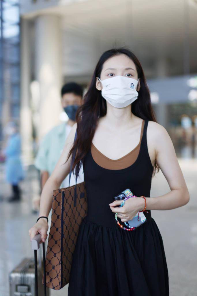 孙伊涵穿假两件吊带长裙现身虹桥机场,尽显优雅范.