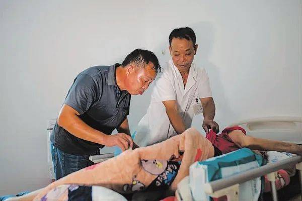 邓经铭为患有痛风的村民刘明辉检查病情.