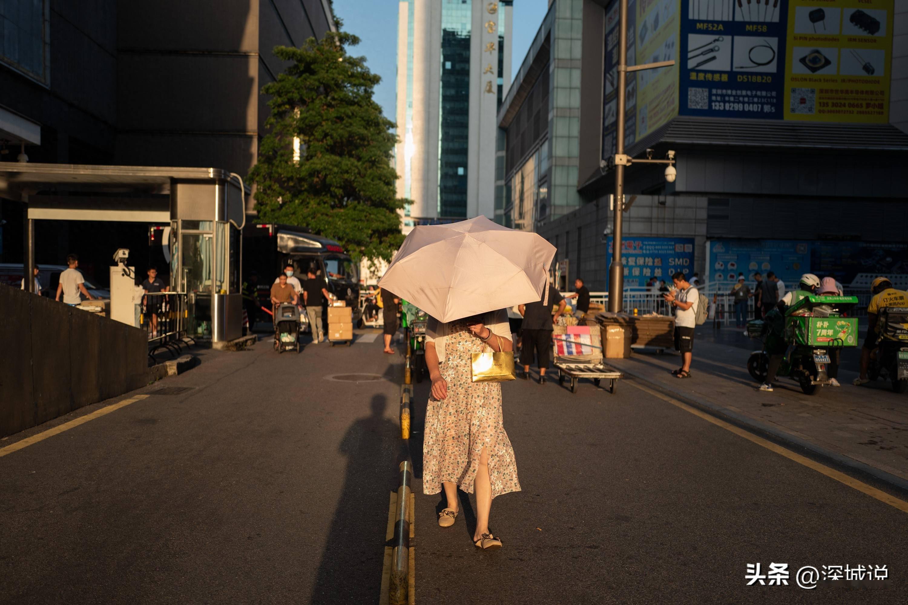 迎着夕阳走路的路人把伞遮住了脸 大量的电单车 返回搜狐