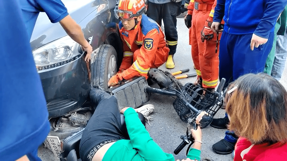 消防员,市民合力抬车救人