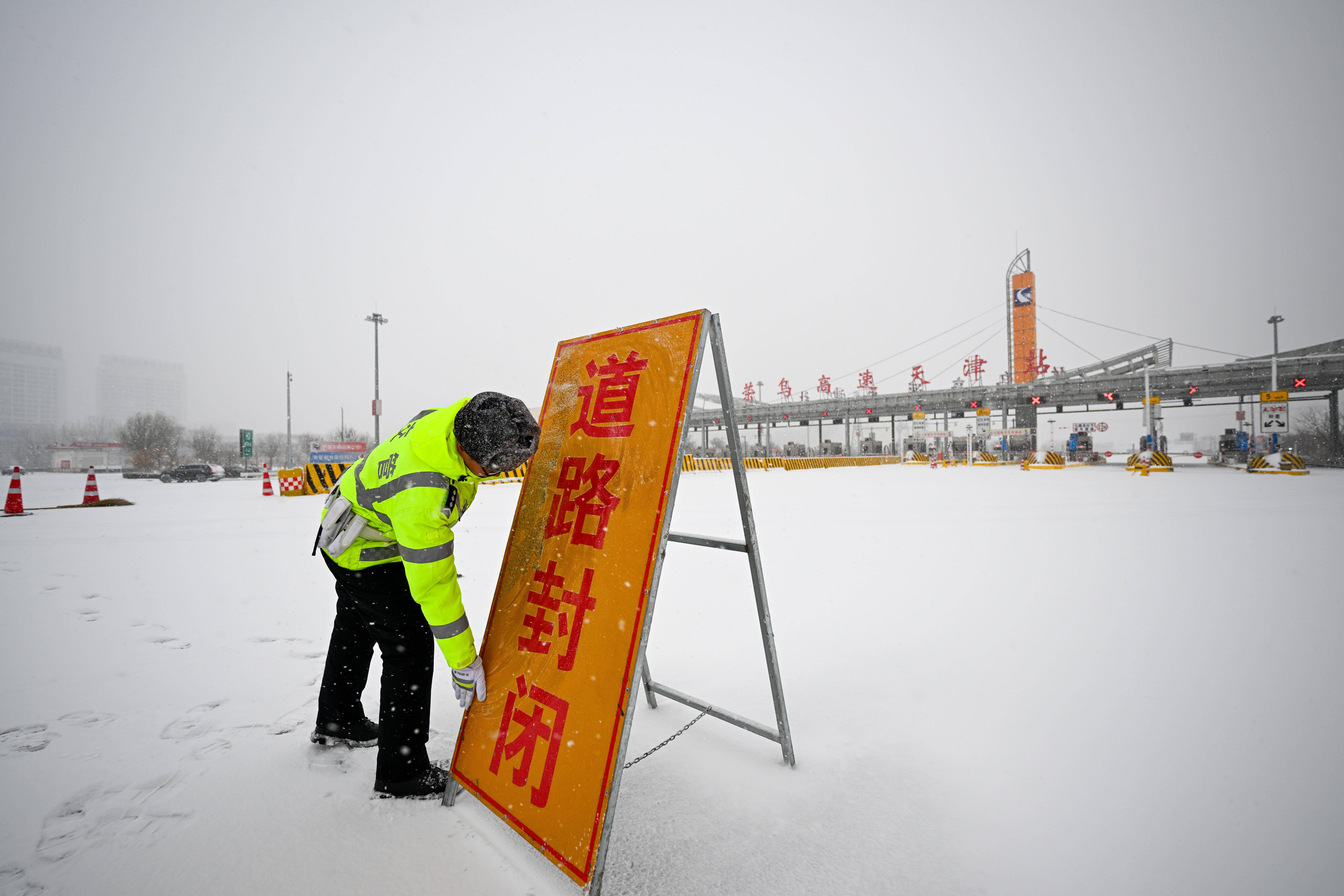 12月14日,在荣乌高速天津收费站,民警摆放高速道路封闭提示牌
